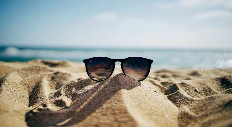 a sunglass stands on sands